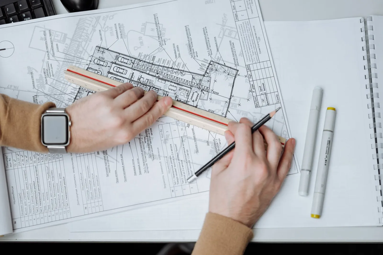 Estimator measuring a drawing set with a scale ruler