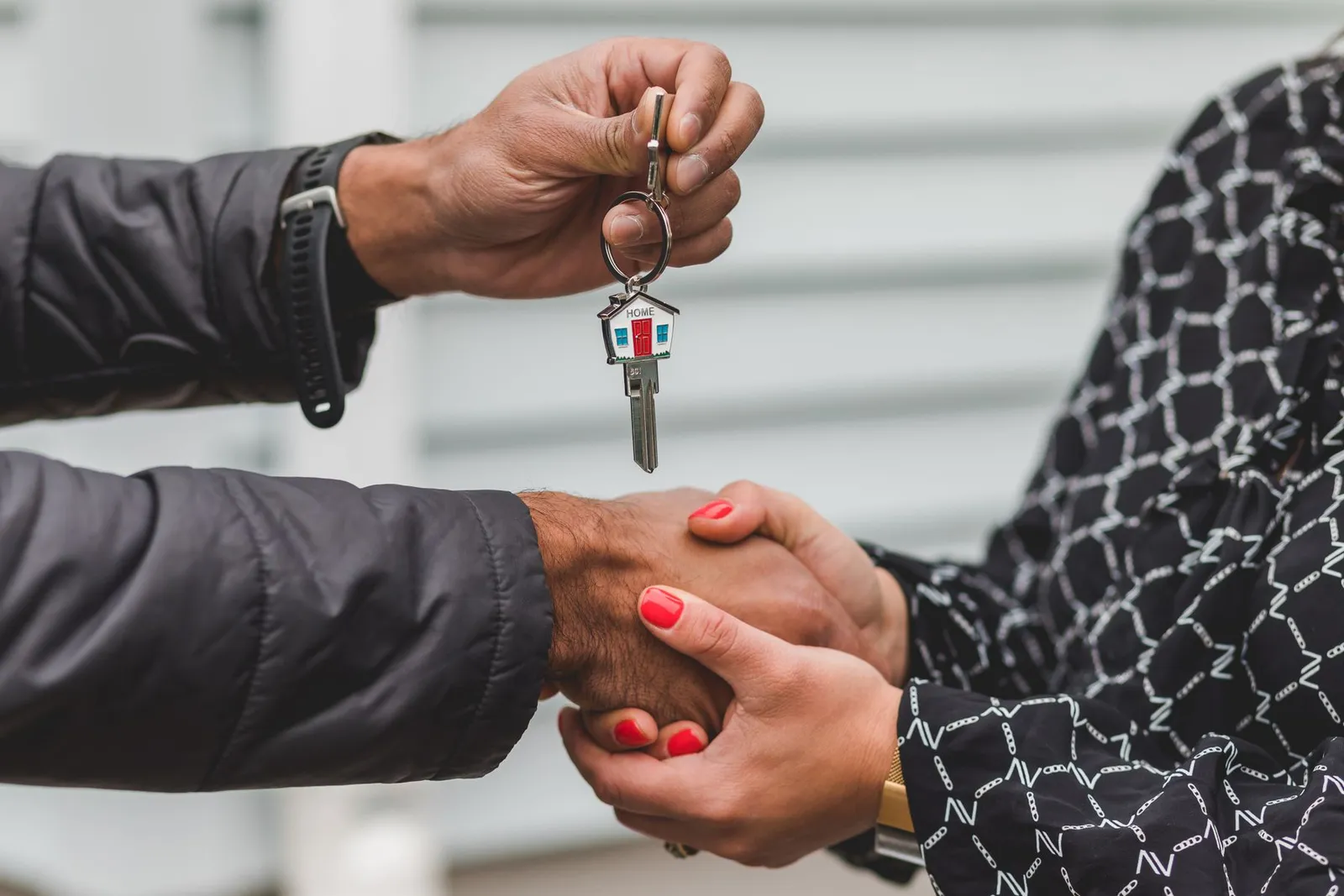 Handshake and house keys at the handover of a home